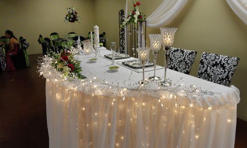 Party Table Set Up with Plates, Glasses, and Flowers at a Reception