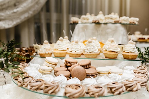 Candy Bar with Macarons, Cakes, Cheesecakes, and Cake Pops on Serving Tray.